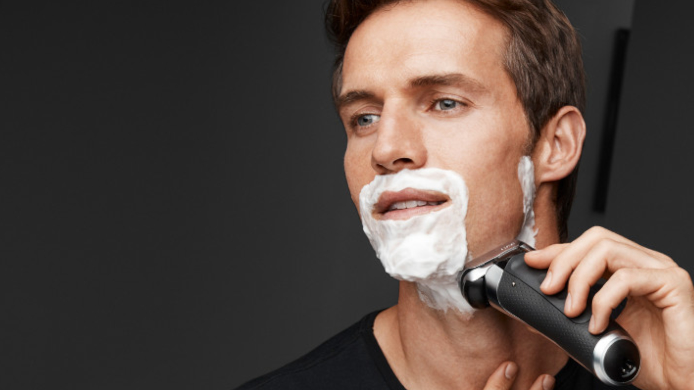 Выбрать бритву мужскую. Сухое бритье. Мужчина бреется электробритвой. Мода на бритье. Мужское лицо бритое.